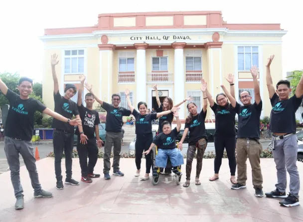 Virtualahan Coaches and students raising their hands in front of the City Hall of Davao.