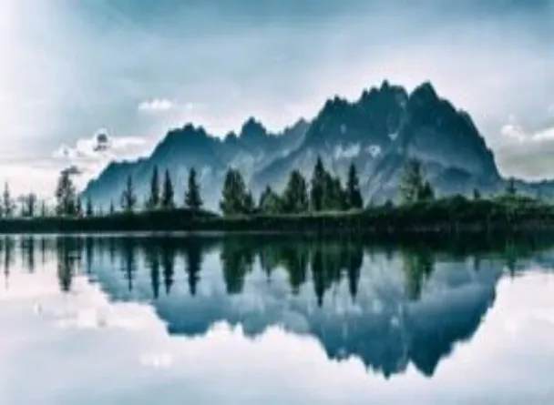 A picture of a lake with a beautiful reflection of a mountain in it.