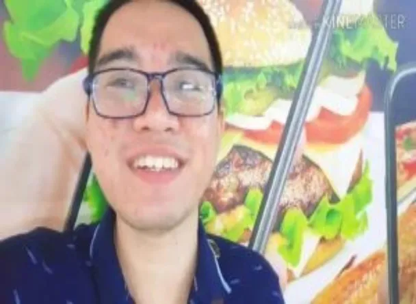 Billicent Macuse pose for a picture in front of a big picture of a burger